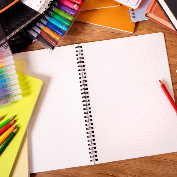 istock College student desk with blank writing book, copy space 1195960831