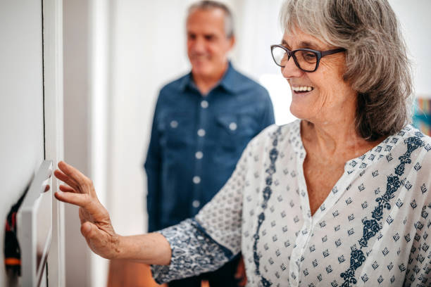 istock Senior woman using home automation touch screen panel in nursing home 1195963388