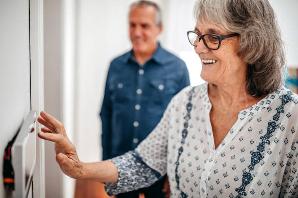 senior kvinna använder home automation pekskärm panel i sjukhem - security home bildbanksfoton och bilder
