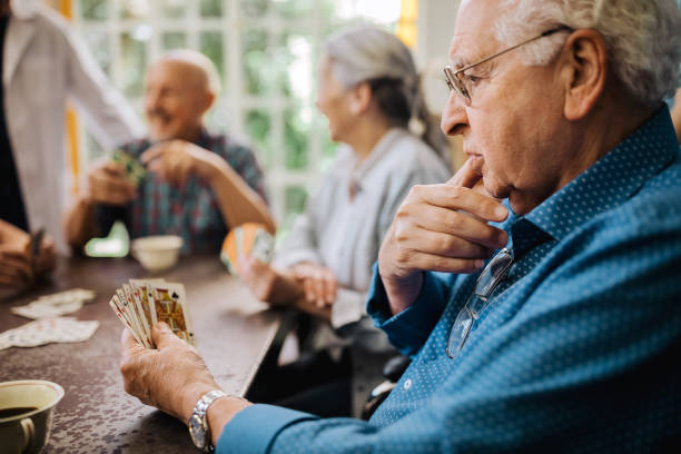 istock Seniors having fun playing cards in nursing home 1195965558