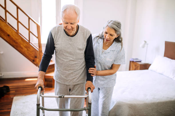 istock Wife is helping her husband with mobility walker at home 1195966992