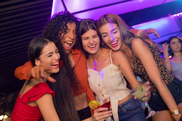 istock Girlfriends celebrating drinking cocktails inside the disco 1195967041
