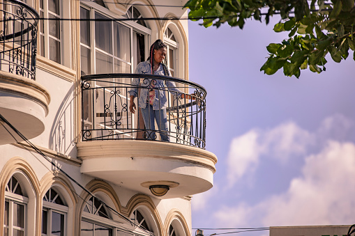 BAYAHIBE, DOMINICAN REPUBLIC 23 DECEMBER 2019: Dominican woman looking out onto the balcony