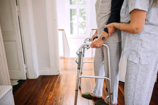 istock Wife is helping her husband with mobility walker at home 1195968140