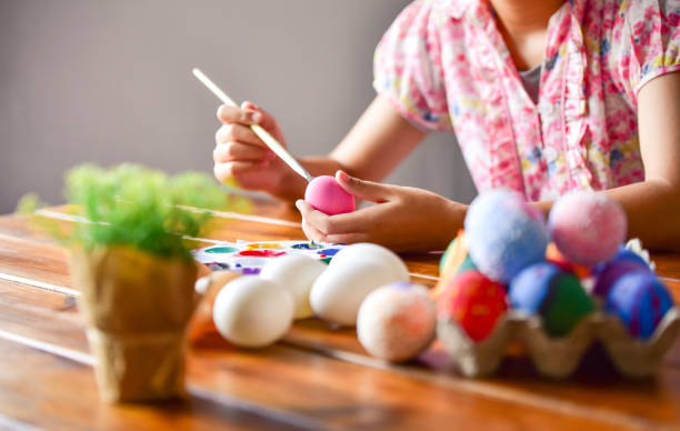 istock young girl painting Easter eggs for eastertime at home 1195977609