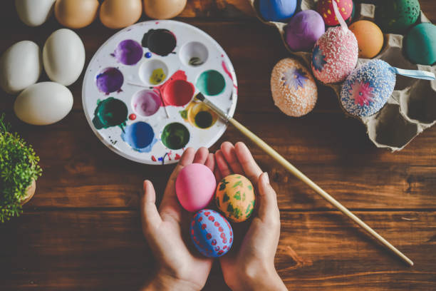 istock young girl painting Easter eggs for eastertime at home 1195977623