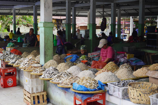 Local stall that selling preserved salted fish and shrimp. Weekly Market at Ambarita Traditional Market. A woman selling their local made seafood product at the market. danau toba lake stock pictures, royalty-free photos & images