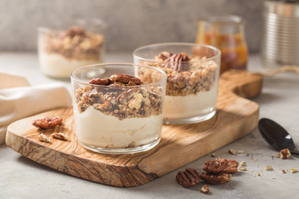Delicious natural yogurt parfait with caramel, pecan nuts on conctere background stock photo