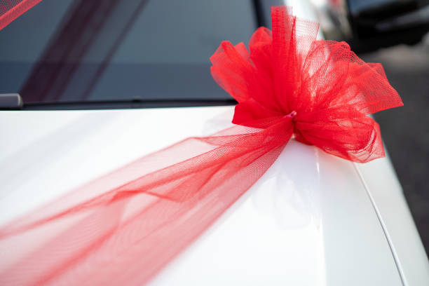 istock Red ribbon decoration on wedding car 1195991457