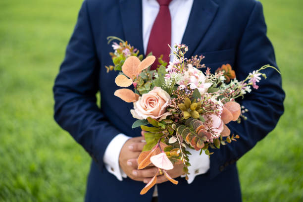 istock Asian man hand holding flower bouquet 1195991464
