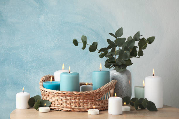 istock Burning candles, basket and vase with eucalyptus against blue background, space for text 1195997736