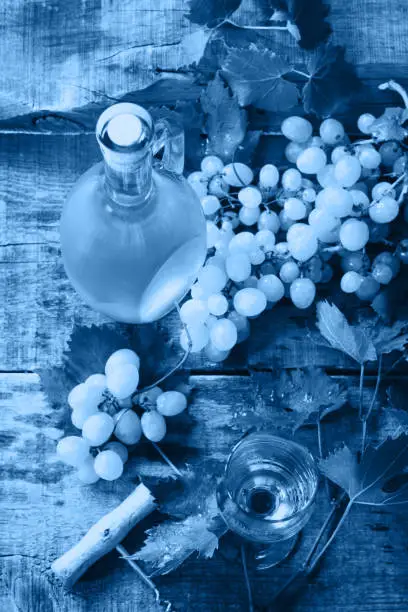 Photo of Classic blue 2020. Gradient color palette. Wine background. Wine in glasses, bottle, grapes on vintage background, wine concept.