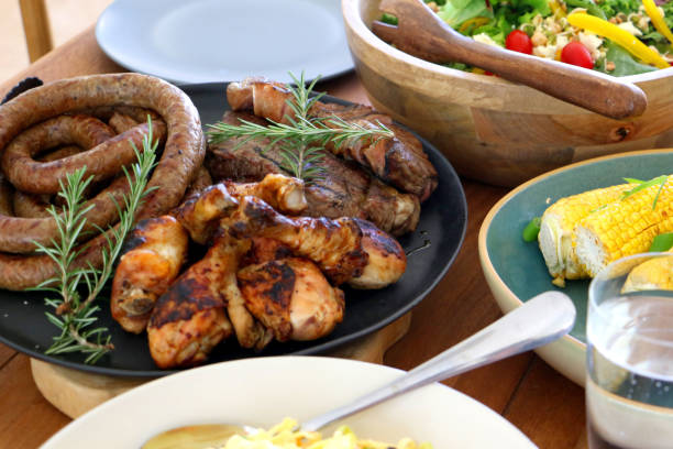 barbeque braai meal ready to eat on table colourful barbeque braai plated meal consisting of chicken, steak, boerewors salad and coleslaw laid out and ready to eat on table wors on a braai stock pictures, royalty-free photos & images