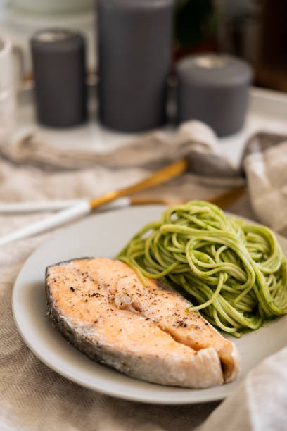 istock green spaghetti and grilled salmon steak. Top view 1195999815