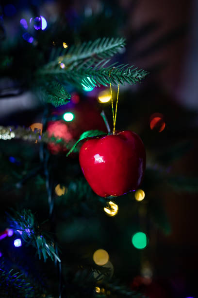 istock Red christmas ball apple shaped hanging on a christmas tree with blurred lights on background copy space 1196001680