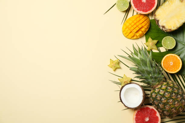 istock Exotic fruits and palm leaves on beige background, space for text 1196002589