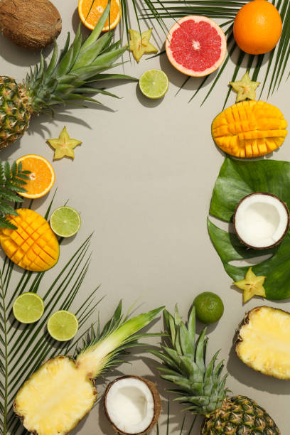 istock Composition with exotic fruits and palm leaves on grey background, space for text 1196003619
