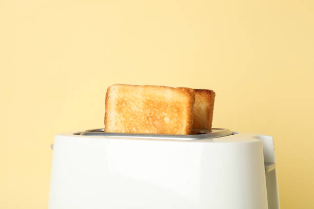 istock Toaster with bread slices on beige background, close up 1196004684