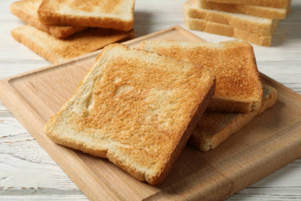istock Board with toasts on white wooden background, close up 1196004776