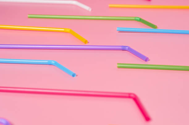 istock Rows of colorful straws for beverage on pink table. Close-up 1196005536