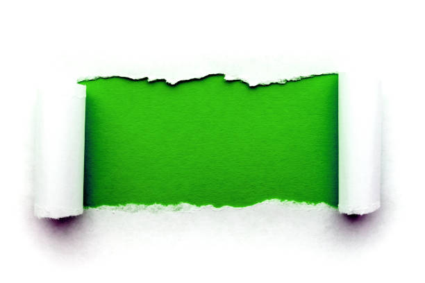 istock A hole in white paper with torn edges isolated on a white background with a bright green color paper background inside. Good paper texture 1196005877