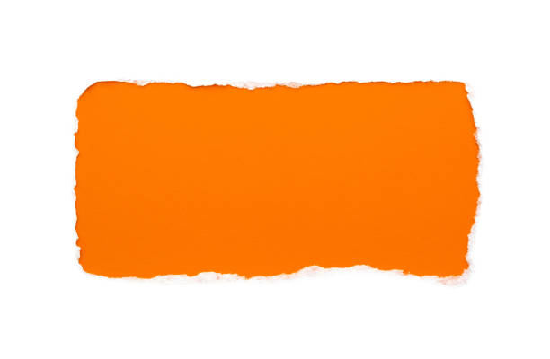 istock A hole in white paper with torn edges isolated on a white background with a bright orange color paper background inside. 1196006497