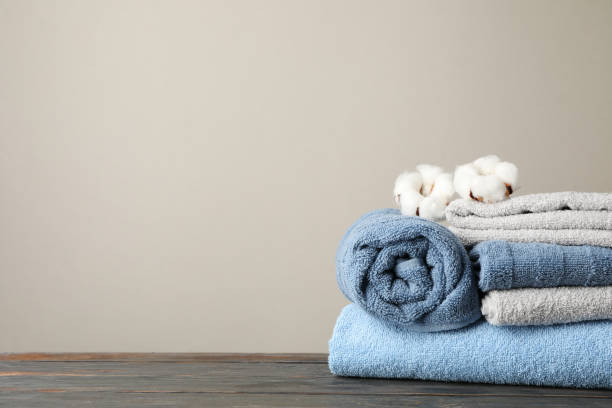 istock Folded towels and cotton on wooden table against grey background, space for text 1196006718