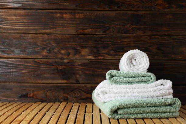 istock Folded towels on bamboo table against wooden background, space for text 1196006789