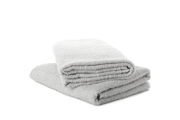 istock Folded grey towels isolated on white background, close upFolded grey towels isolated on white background, close up 1196006836