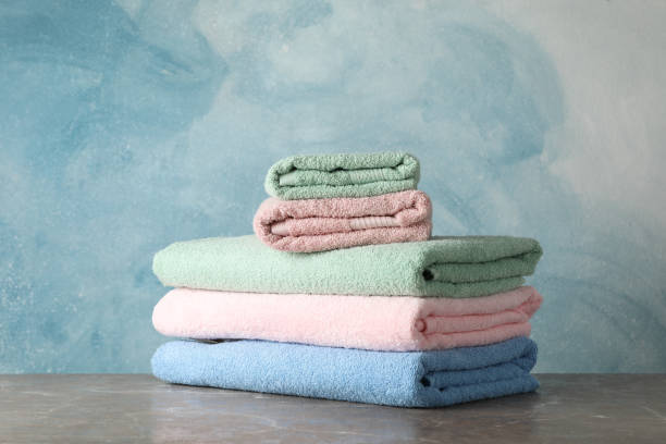 istock Stack of color towels on grey table against blue background, space for text 1196007620