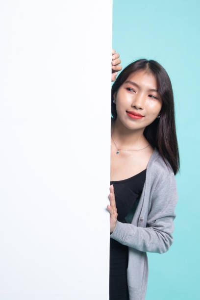 istock Young Asian woman with blank sign. 1196008436