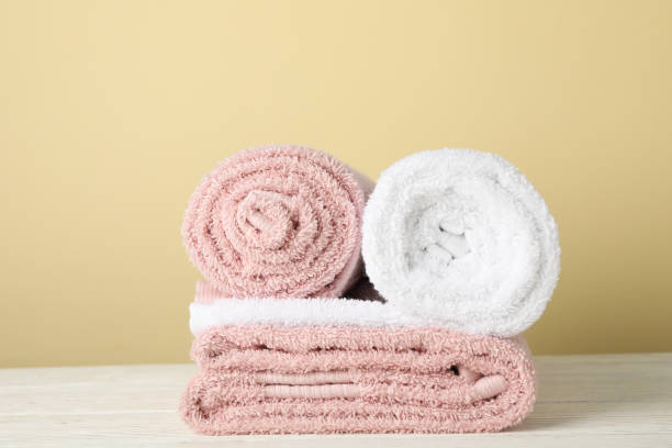 istock Folded towels on white wooden table against beige background, space for text 1196008512