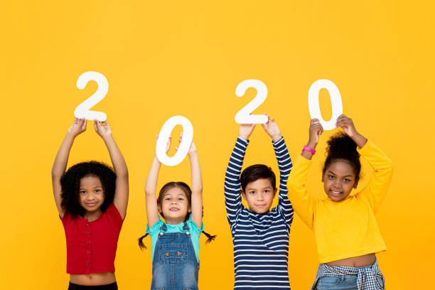 istock Cute mixed race kids smiling and holding 2020 numbers 1196008582
