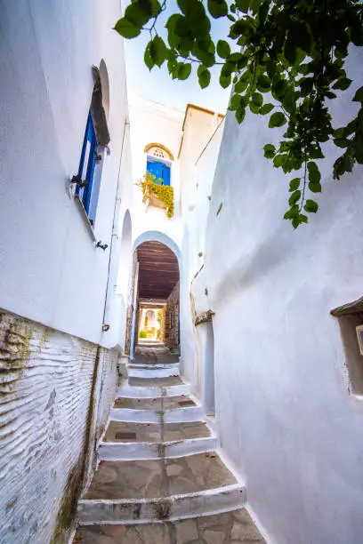 Photo of Narrow neighborhood streets and buildings at the old traditional village of Tripotamos, Tinos, Greece.
