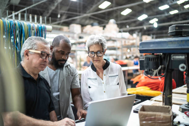 istock Coworkers using laptop and working together in factory 1196010583