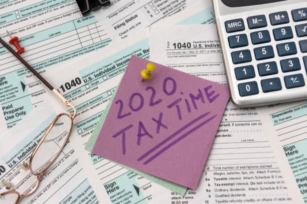 2020 r. spółka podatkowa. kolorowe naklejki z przypomnieniem na formularzu podatkowym 1040 z bliska - tax tax form financial advisor calculator zdjęcia i obrazy z banku zdjęć