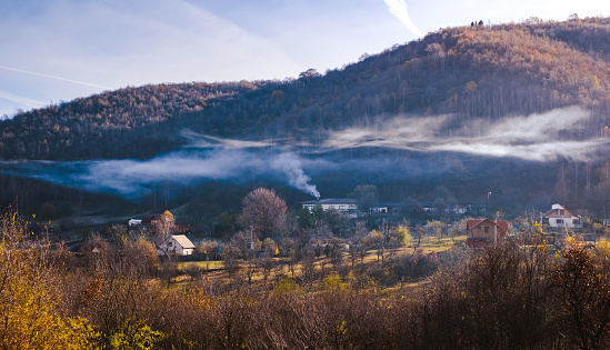Smoke from the kitchen chimney over the autumn village, Fantanele village, Sibiu county, Romania
