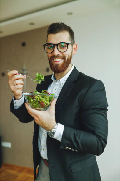istock Businessman eating healthy salad 1196018144