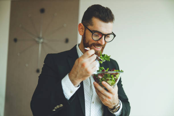 istock Businessman eating vegetable salad 1196018951