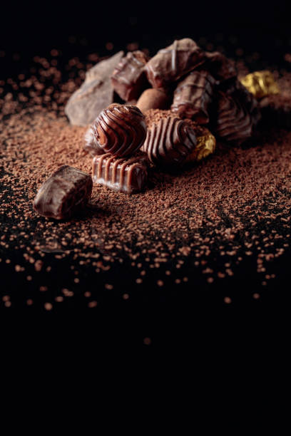 istock Various chocolate candies with chocolate chips on a black reflective background. 1196019187