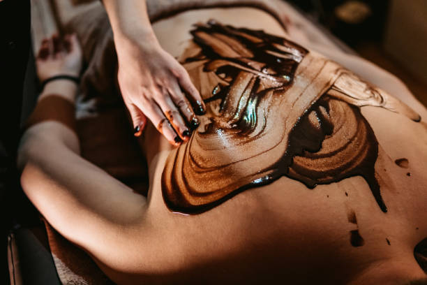 молодой человек наслаждаясь массаж с шоколадом - massaging chocolate spa treatment body стоковые фото и изображения