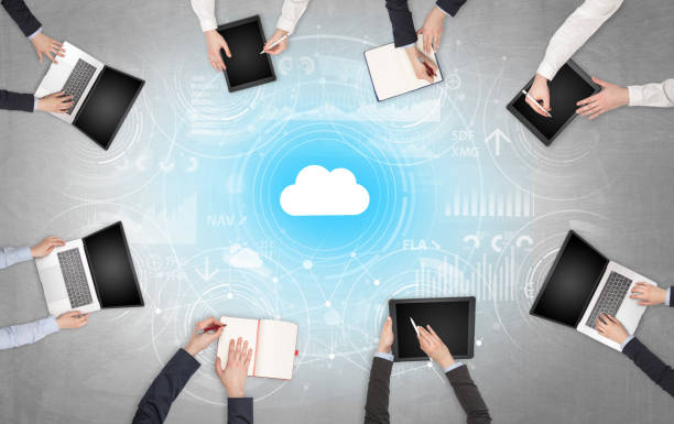 istock Group of people with devices in hands working on laptops and tablets with online teamwork concept 1196022030