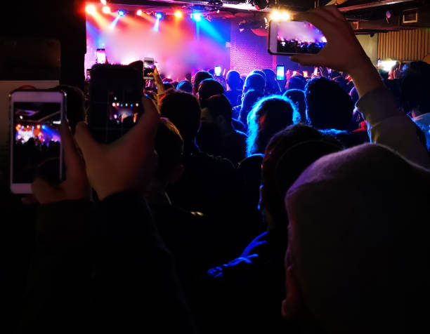 istock Smartphone in hand at a concert, purple light from stage 1196023167