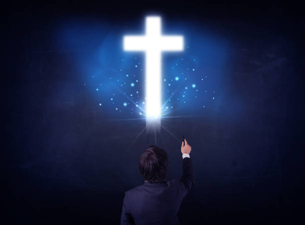 istock Businessman in front of a glowing cross 1196025247
