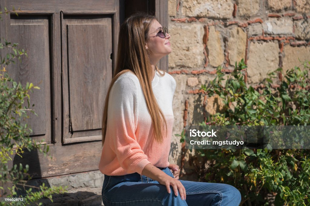 Young pretty women waiting old rustic entrance door 20-29 Years Stock Photo