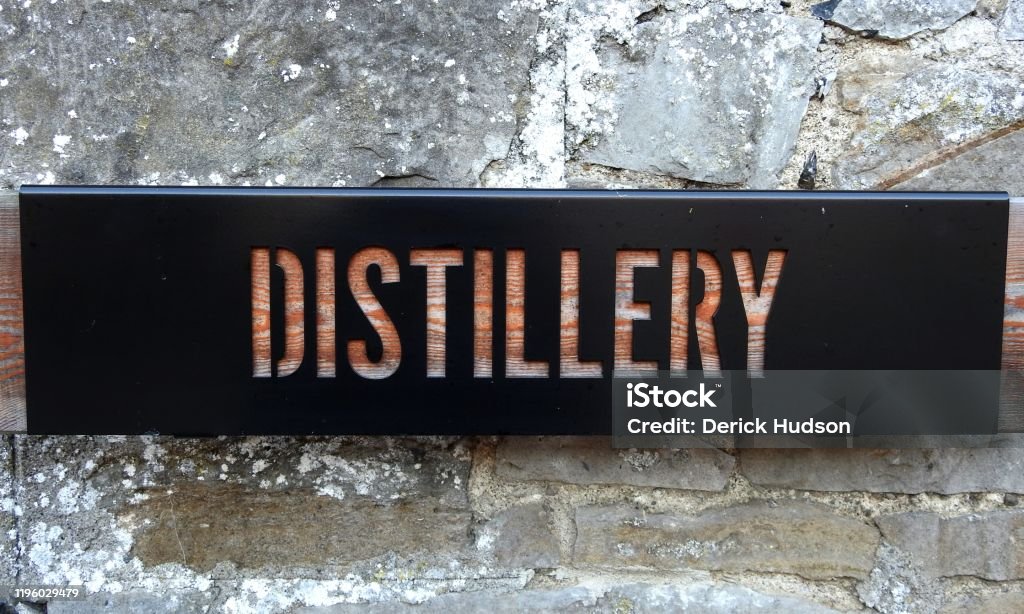 Distillery sign Distillery sign cut out from wood on brick wall. Distillery Stock Photo