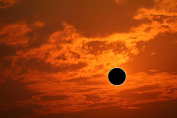 istock phenomenon of partial sun eclipse over silhouette orange cloud and sunset sky 1196032133