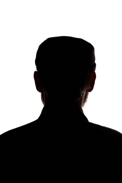 istock Old man in peaked cap, rear view - dark close-up silhouette 1196033085