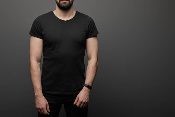 cropped view of bearded man in blank basic black t-shirt on black background