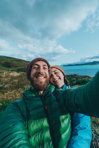 Selfie of young Caucasian couple on the background of lake in  Torres del Paine National Park